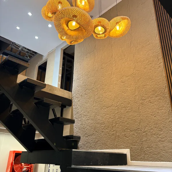 Lámparas Bali doradas sobre pared rugosa beige