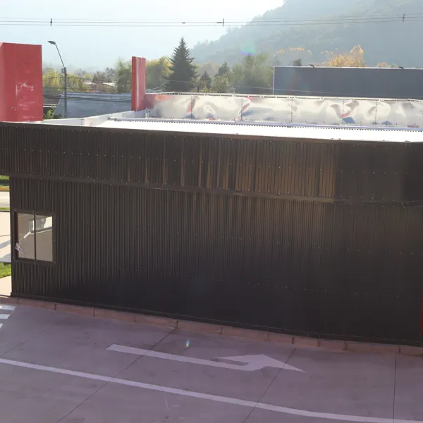 Módulo curvo revestido en negro con la cordillera al fondo