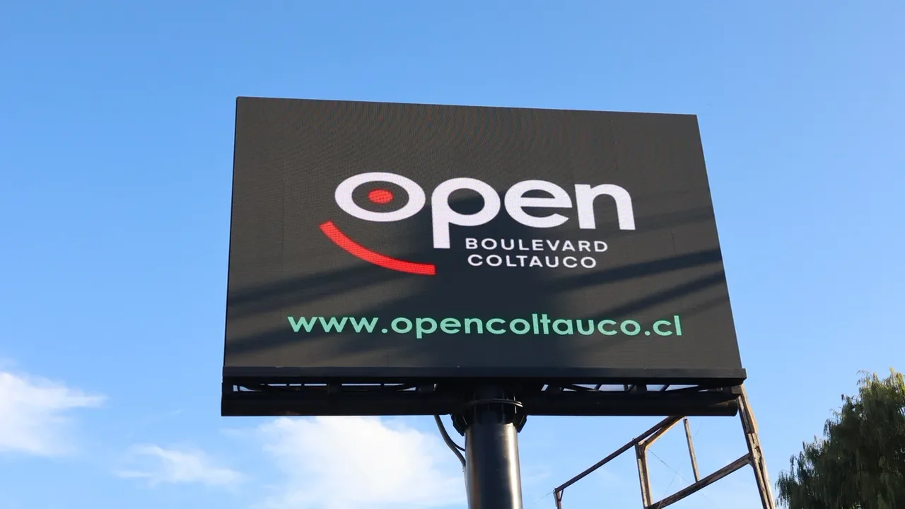 Pantalla LED de Open Boulevard Coltauco encendida mostrando el logo Open Boulevard Coltauco contra cielo azul intenso